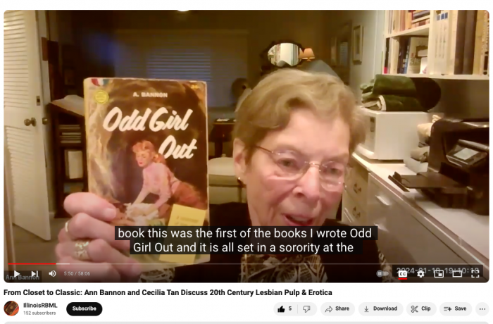 Writer Ann Bannon via Zoom holds up a copy of her book Odd Girl Out during an online discussion